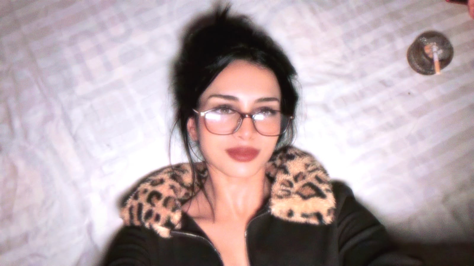 Fartashia wearing glasses and a jacket with a patterned collar